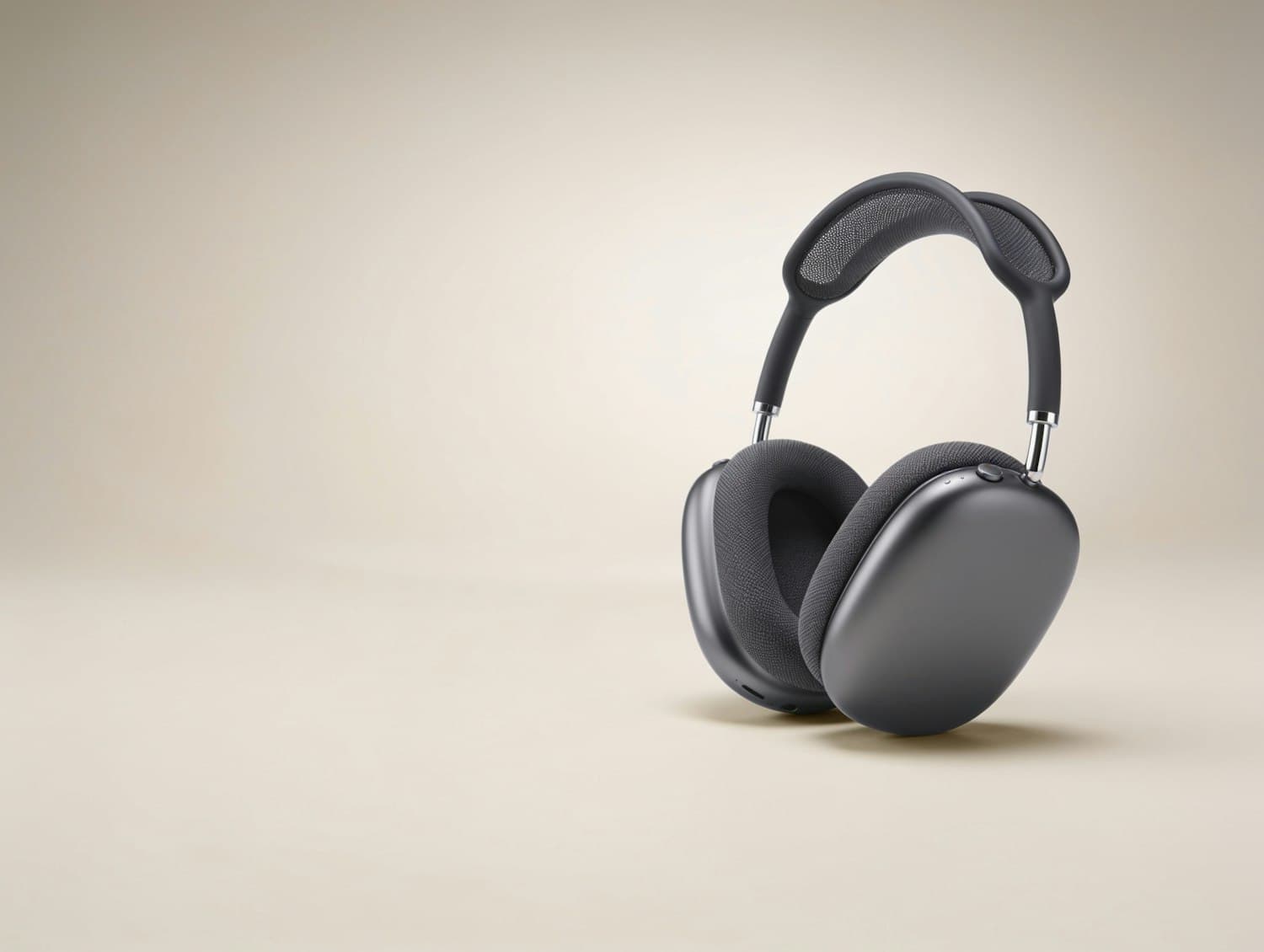 Graphite over-ear wireless headphones with a knit-mesh headband on a warm beige backdrop